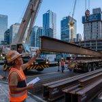 Foreman Overseeing The Unloading Of Construction Steel